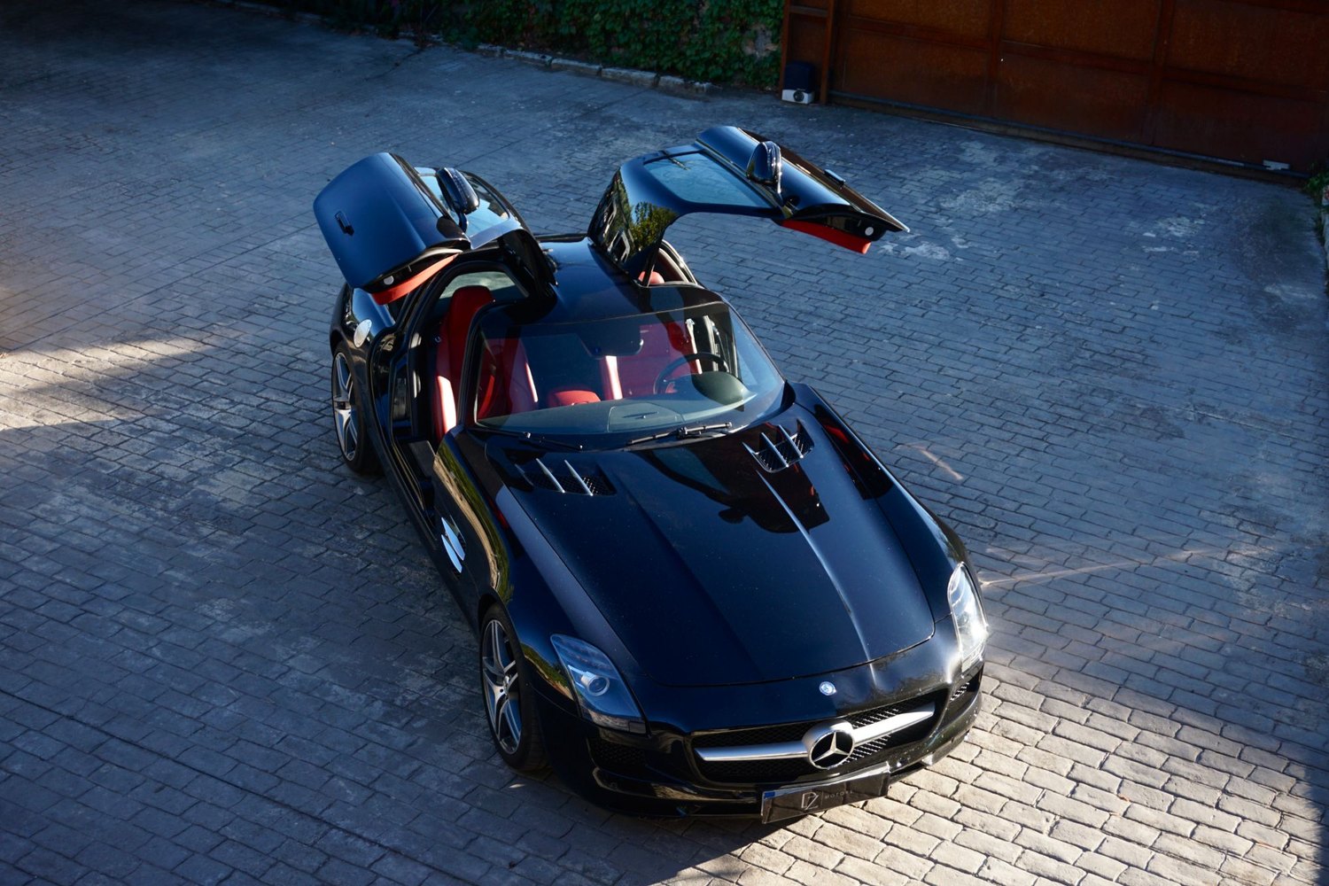 Mercedes-Benz SLS AMG negro con las puertas de gaviota abiertas